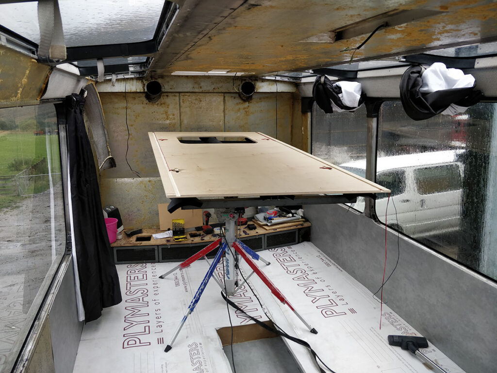 Installing the ceiling panels with the lifter with a custom built frame that can match the curve of the bus ceiling to push the panel into the curve.