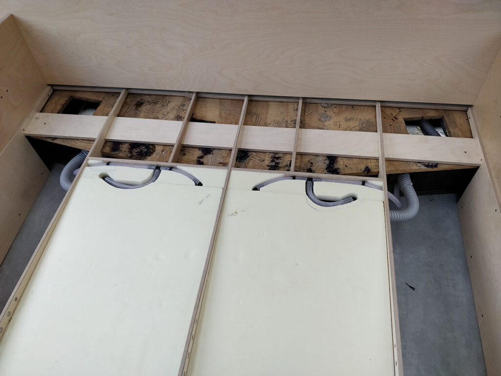Insulation cut around plumbing on fresh water tanks under bed.