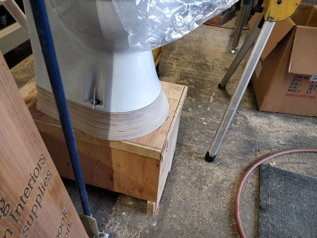 The 3 degree Birch ply wedge that we glued up and machined to level the toilet up on the sloping bus floor. Took a bit of sanding.