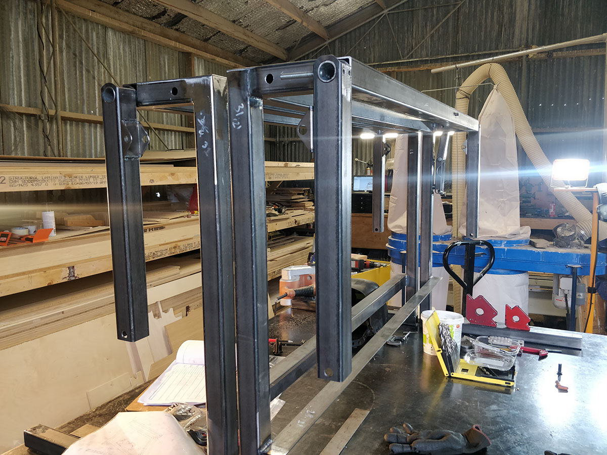 The arms hanging from the main frame that will support the bunk when raised.